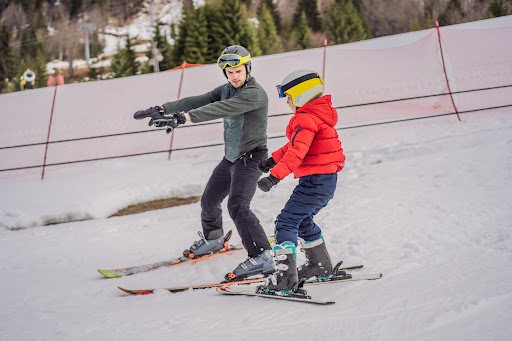 A ski instructor teaches a boy