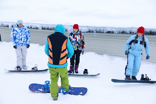A snowboard instructor teaches a group
